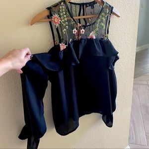Small black long sleeve open shoulder ruffle blouse with floral embroidery